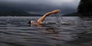 Homme nageant le crawl dans un lac