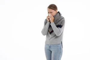 femme debout se mouchant le nez