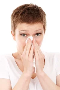 Femme se mouchant le nez