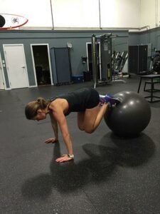 Femme qui fait des gaine avec un ballon sous les pieds